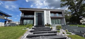 Porta pivotante em ACM preto fosco com portais duplos laterais em vidro. - Imagem 8