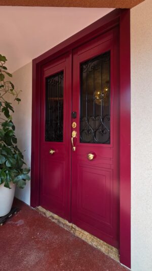 Porta em ACM com sistema de abertura dupla em estilo colonial, equipada com grade em ferro, aldrava decorativa, fechaduras blim blim e digital - Imagem 2