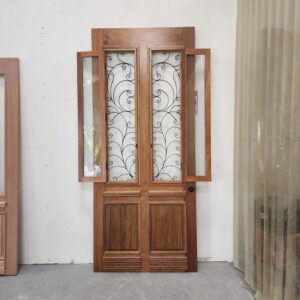 Porta com sistema de abertura dupla, equipada com grade de ferro e postigo móvel, unindo segurança e praticidade no uso diário