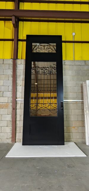 Porta pivotante em ACM com vidro e grade decorativa, unindo modernidade, segurança e elegância