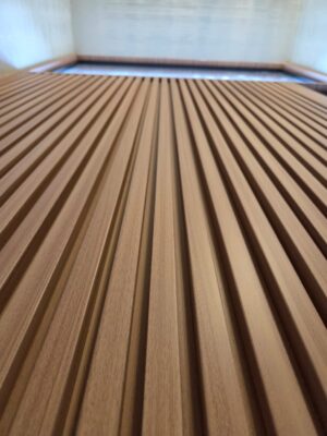 Porta pivotante em ACM modelo ripado, com portal e bandeira em vidro, destacando leveza e sofisticação no projeto - Imagem 5