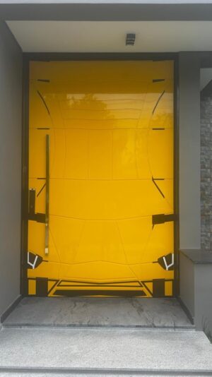 Porta pivotante em ACM modelo Lamborghini exclusivo, desenvolvida para atender pedido especial do cliente. Design moderno e imponente