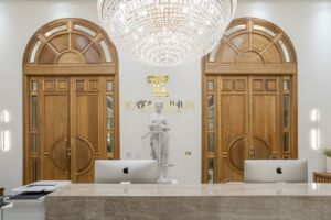 Porta em madeira maciça com sistema de abertura dupla, arco superior curvo e portal lateral com vidro fixo. Modelo exclusivo, produzido sob medida