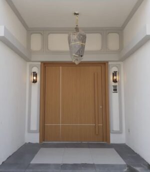 Porta pivotante em ACM, com frisos decorativos