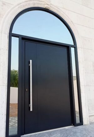 Porta pivotante em ACM com bandeira superior em arco, destacando o design arquitetônico