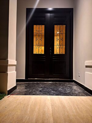 Porta em ACM com sistema de abertura dupla, modelo colonial, com grade de ferro e acabamento sofisticado