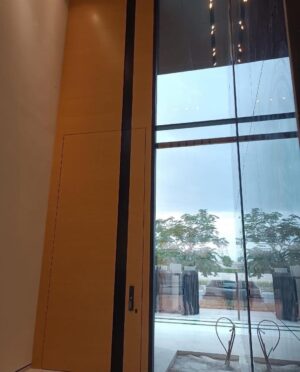 Porta pivotante em ACM com puxador cava e banderia superior fixa - Imagem 4