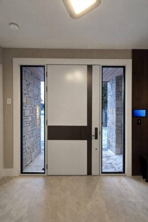 Porta em ACM bicolor (branco interno e madeirado externo), com puxador em ferro e design moderno, acompanhada de portal duplo lateral com vidro